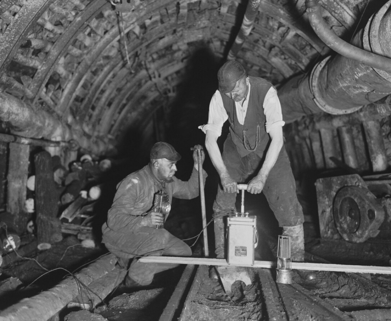 Górnicy detonują ładunek w kopalni. Zdjęcie monochromatyczne