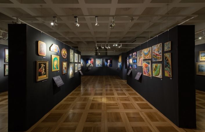 Sala wystawowa w Zamku. Po lewej stronie wiszą obrazy religijne. Po prawej stronie abstrakcje.