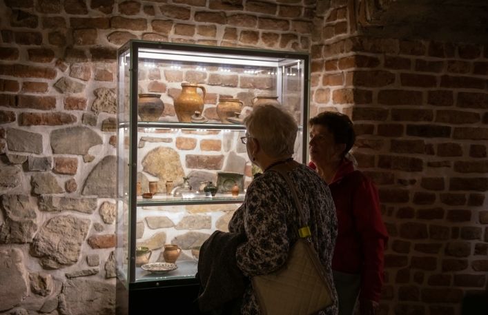Dwie starsze panie oglądają gablotę ze zbiorami archeologicznymi