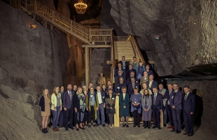 Zdjęcie grupowe uczestników konferencji na schodach w komorze Saurau