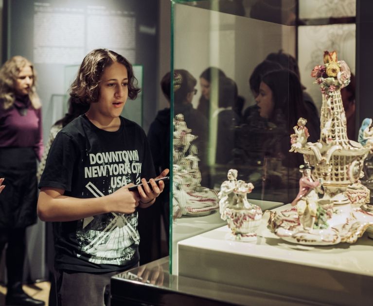 chłopiec ogląda porcelanowy zestaw przyprawowy w gablocie w sali muzeum Zamku