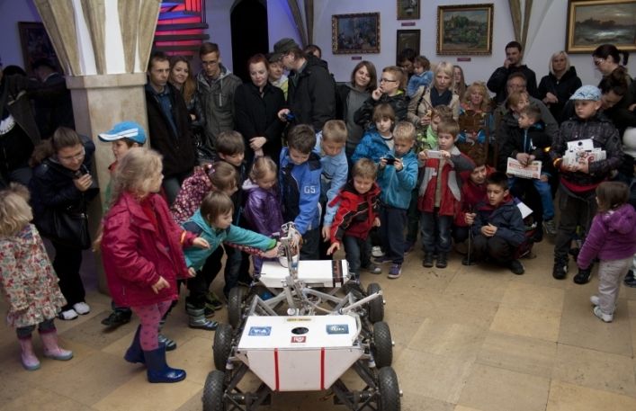 Tłum dzieci ogląda z zainteresowaniem pojazd kosmiczny w sali gotyckiej w Zamku.