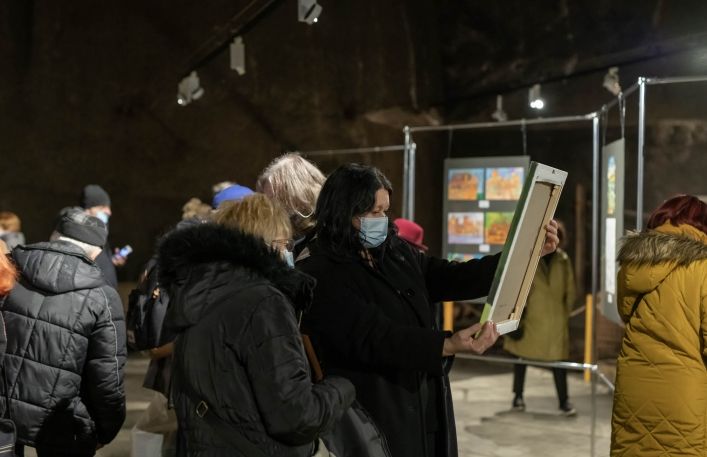 Magdalena Waśniowska- Nowak ogłada obraz trzymając go w rękach. Obok starsza kobieta.
