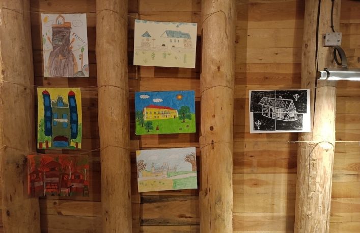Prace konkursowe powieszone na drewnianych obudowach w sali edukacyjnej Muzeum w kopalni soli.