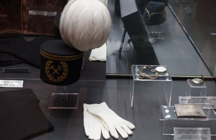 Gablota z czakiem górniczym z białym pióropuszem, białe rękawiczki do munduru oraz zegarki górnicze.
