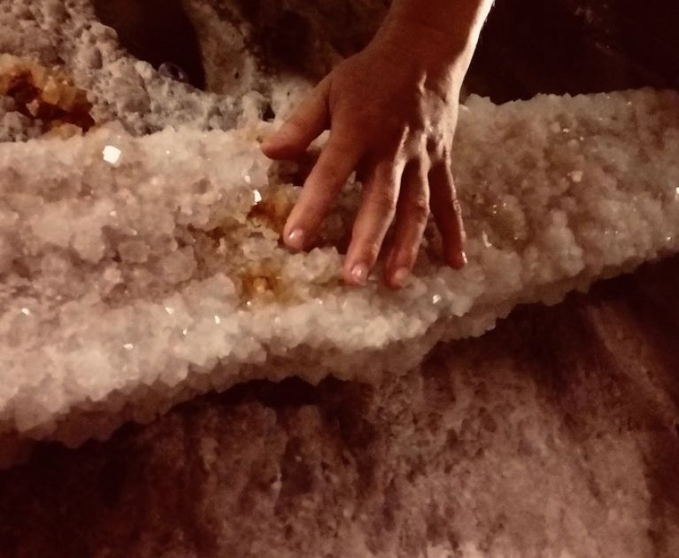 widok na dłoń dotykająca solne krysztły