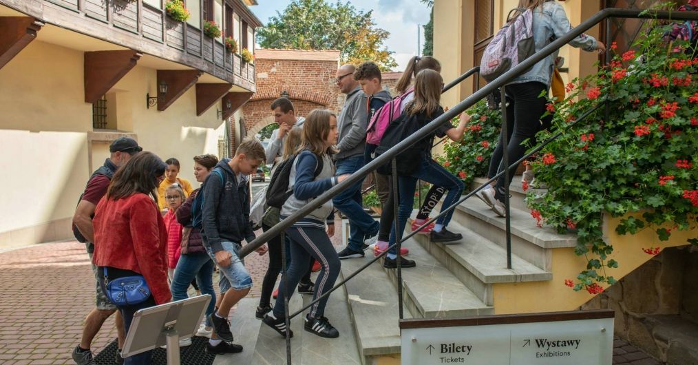 Grupa młodzieży wchodzi po schodach do Zamku Żupnego.
